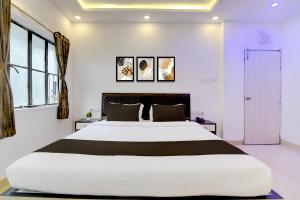 a large white bed in a room with windows at Hotel O Acroview in Ballygunge