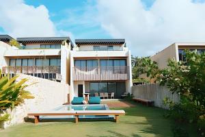 Cette maison dispose d'une terrasse et d'une table dans la cour. dans l'établissement Casa Pé na Areia | Rooftop, 5 suítes, piscina, à Barra do Camaragibe