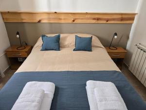 a bedroom with a large bed with blue and white pillows at SIMPLE Inn in El Chalten