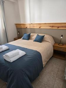 a bedroom with two beds with blue and white pillows at SIMPLE Inn in El Chalten +13 photos