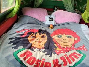 リンカーンにあるSmall Rosie River Glamping Pod for 2のベッドの上には看板の付いた人形が2体