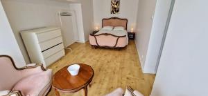 a small bedroom with a bed and a table at Le Clos Beau Jardin in Gaillan-en-Médoc