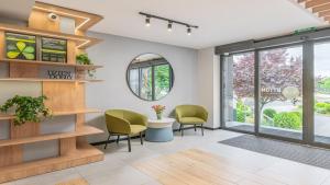 a waiting room with green chairs and a table at B&B HOTEL Bytom in Bytom
