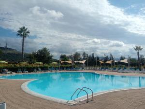 a large swimming pool with chairs and umbrellas at Costa degli Dei apartment in Pizzo