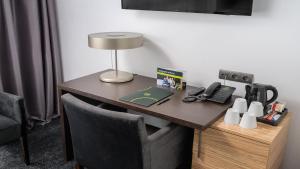 a desk with a lamp and a telephone on it at B&B HOTEL Bytom in Bytom