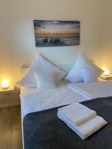 a bedroom with two beds with white sheets and pillows at FeWo Diemelblick in Diemelsee