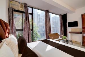 ein Hotelzimmer mit einem Bett und großen Fenstern in der Unterkunft Collection O Sector 7 Dwarka Formerly Aakarshan Residency in Dwarka, New Delhi