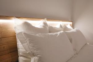 een stapel witte kussens op een bed bij Suite con spa privata disponibile su richiesta in Maso
