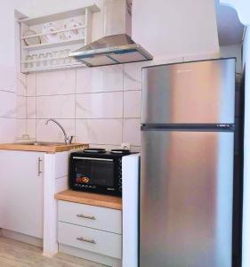 a kitchen with a stainless steel refrigerator and a microwave at Venetos Studios in Livadi Astypalaias