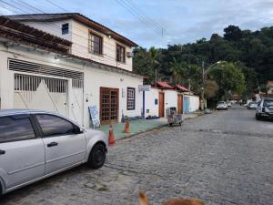 a white car parked on the side of a street at Pousada Dádiva girassol encantado Pontal Centro in Paraty