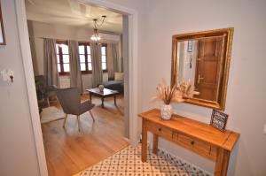 a living room with a table and a mirror at Apozari Xenias Apt in Kastoria