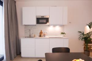 een keuken met witte kasten en een magnetron bij Suite con spa privata disponibile su richiesta in Maso