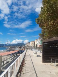 Una pasarela junto al agua con bancos y edificios. en Caruggio al mare, en Savona