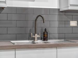 a bottle of wine sitting on a kitchen sink at The Azure Hideaway 2BR 2BA City Centre in Leicester +35 photos