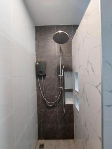 a shower with a shower head in a bathroom at J House Has Love in Sukhothai