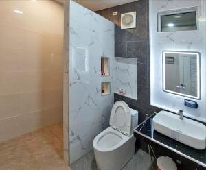 a bathroom with a white toilet and a sink at J House Has Love in Sukhothai