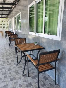 a table and chairs in a room with windows at J House Has Love in Sukhothai +12 photos