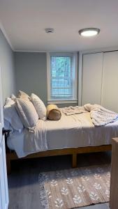 a bedroom with a bed with pillows and a window at Contemporary Apartment- Prime Location to MBTA in Pawtucket +37 photos