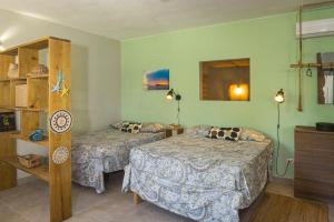 a hotel room with two beds and a shelf at Cabarete Boutique Kite Hotel Garden Loft in Cabarete