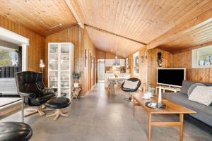 ein Wohnzimmer mit Couch und Stühlen in der Unterkunft TV1689 Strandby - Klitmarken 4 in Strandby