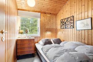 ein Schlafzimmer mit einem Bett in einer Holzwand in der Unterkunft TV1689 Strandby - Klitmarken 4 in Strandby
