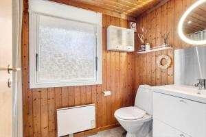 ein Badezimmer mit Toilette und Waschbecken und einem Fenster in der Unterkunft TV1689 Strandby - Klitmarken 4 in Strandby + 21 Fotos