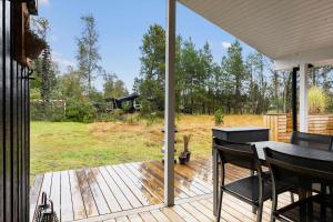 eine Terrasse mit Tisch und Stühlen auf einem Deck in der Unterkunft TV1689 Strandby - Klitmarken 4 in Strandby