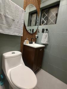 a bathroom with a toilet and a sink and a mirror at Amber Apartment at Downtown in Chihuahua