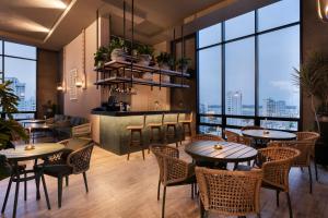 a restaurant with tables and chairs and large windows at OZ Hotel Collection in Cartagena de Indias
