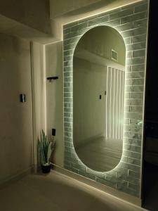 a bathroom with a mirror on a brick wall at Amber Apartment at Downtown in Chihuahua