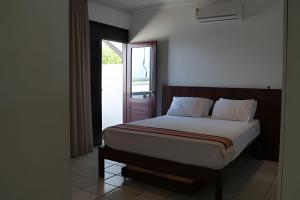 a bedroom with a bed and a window with a door at Casa Bruma |Pé na areia, encontro do rio com o mar in Francês +20 photos