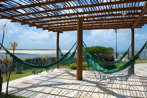 a hammock under a pergola with a view of the ocean at Casa Bruma |Pé na areia, encontro do rio com o mar in Francês