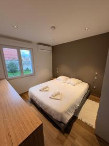 Un dormitorio con una cama con dos toallas encima. en Gite Spa L'Atelier Emile - Spa Privatif - 5 min COLMAR, en Sainte-Croix-en-Plaine