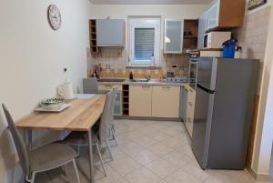 a kitchen with a table and a stainless steel refrigerator at Apartma Laura in Ankaran