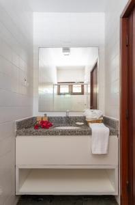 ein Badezimmer mit Waschbecken und Spiegel in der Unterkunft Casa Maré | Pé na Areia em Praia Bonita/AL in Barra de São Miguel + 17 Fotos