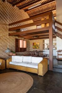 ein Wohnzimmer mit einem großen Sofa und einem Tisch in der Unterkunft Casa Maré | Pé na Areia em Praia Bonita/AL in Barra de São Miguel