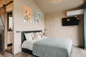 a bedroom with a bed and a flat screen tv at IKnamai - namelis dviems Aistis in Sakiniai