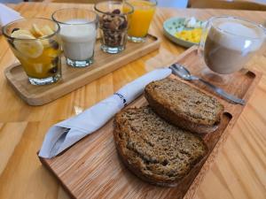a wooden table with two slices of bread and drinks at SIMPLE Inn in El Chalten