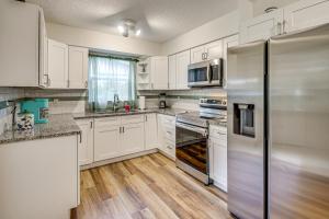 een keuken met witte kasten en een roestvrijstalen koelkast bij Game Room, Yard Home 3 Mi to Daytona Beach! in Holly Hill