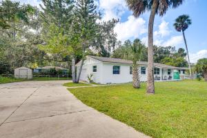 een wit huis met palmbomen en een stoep bij Game Room, Yard Home 3 Mi to Daytona Beach! in Holly Hill