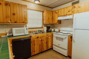 una cucina con mobili in legno e un frigorifero bianco di Frio Country #19 a Concan