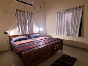 a bedroom with a large wooden bed in a room at Roameo, Varkala - A Cowork by The Hostel Stories in Varkala +3 photos