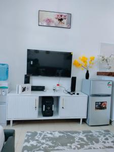 a living room with a flat screen tv on a wall at Cutie Coastal Studio in Mombasa +4 photos