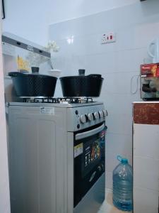 a kitchen with two pots on top of a stove at Cutie Coastal Studio in Mombasa