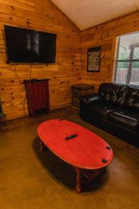 un soggiorno con divano nero e tavolo rosso di Frio Country #20 a Concan