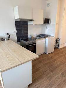a kitchen with white appliances and a wooden floor at Un cocon neuf et lumineux aux portes de Paris in Champigny-sur-Marne +2 photos