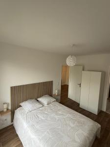 a bedroom with a large bed and a room with cabinets at Un cocon neuf et lumineux aux portes de Paris in Champigny-sur-Marne