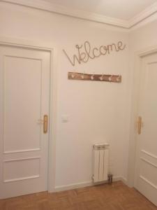 a room with a door and a welcome sign on the wall at Apartamento con gran terraza in San Vicente de la Barquera