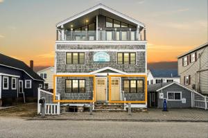 una casa con una puerta amarilla encima en Serendipity Beach Retreat Namaste Unit, en Salisbury Beach