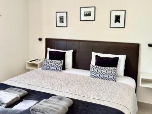 a bedroom with a large bed with black and white pillows at Studio Conexión Mendoza ubicación ideal, WiFi rápido y cerca del Parque San Martín y Av Arístides in Godoy Cruz